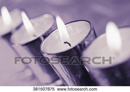 Close-up of a row of lit candles in glasses View Large Photo Image Stock Photography - Close-up of a row of lit candles in glasses. Fotosearch