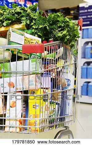 Stock Image - Close-up of a shopping cart loaded with grocery. Fotosearch
