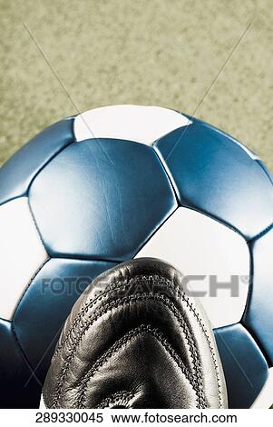 Stock Photography - Close-up of a soccer ball with a sports shoe. Fotosearch