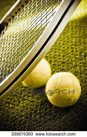 Close-up of a tennis racket and tennis balls in a court View Large Photo Image Stock Image - Close-up of a tennis racket and tennis balls in a court. Fotosearch