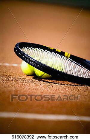 Close-up of a tennis racket and tennis balls in a court View Large Photo Image Stock Image - Close-up of a tennis racket and tennis balls in a court. Fotosearch