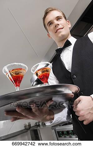 Close-up of a waiter holding a tray of martini glasses View Large Photo Image Stock Image - Close-up of a waiter holding a tray of martini glasses. Fotosearch
