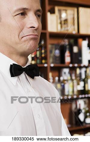 Stock Photography - Close-up of a waiter looking displeased. Fotosearch