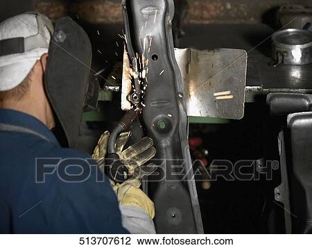 Stock Image - Close-up of a welder welding in a workshop. Fotosearch