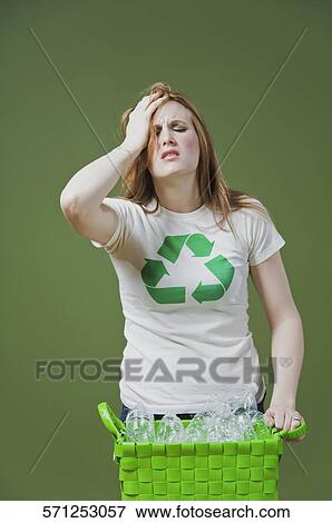 Close-up of a woman holding a recycling bin and looking tired View Large Photo Image Stock Photo - Close-up of a woman holding a recycling bin and looking tired. Fotosearch