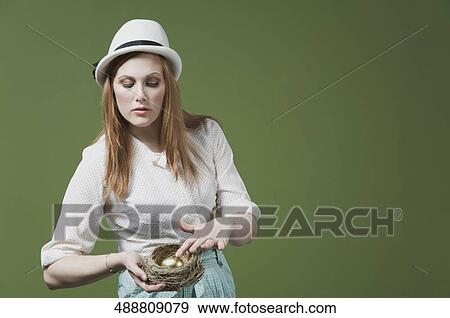Close-up of a woman showing a golden egg in the nest View Large Photo Image Stock Photo - Close-up of a woman showing a golden egg in the nest. Fotosearch