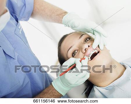 Stock Photograph - Close-up of a young woman getting dental treatment. Fotosearch