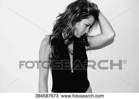 Close-up of a young woman with her hand in her hair View Large Photo Image Stock Image - Close-up of a young woman with her hand in her hair. Fotosearch