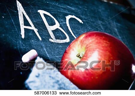 Stock Image - Close-up of an apple on a blackboard. Fotosearch