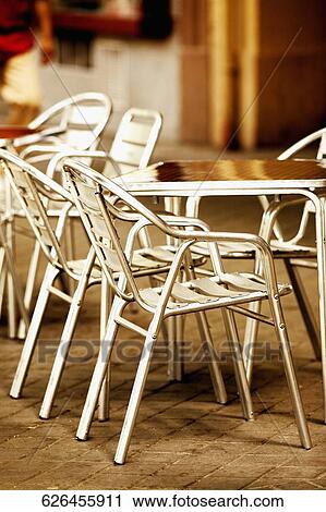 Close-up of an empty table and chairs in a sidewalk cafe View Large Photo Image Stock Image - Close-up of an empty table and chairs in a sidewalk cafe. Fotosearch
