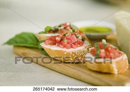 Stock Image - Close-up of bread garnished with tomato. Fotosearch