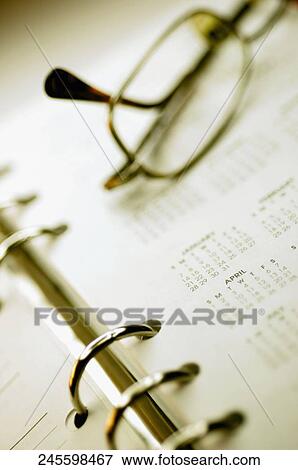 Close-up of eyeglasses on a personal organizer View Large Photo Image Stock Photo - Close-up of eyeglasses on a personal organizer. Fotosearch