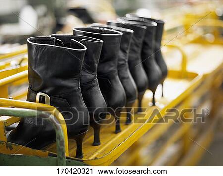 Stock Image - Close-up of leather boots on a shelf in a factory. Fotosearch