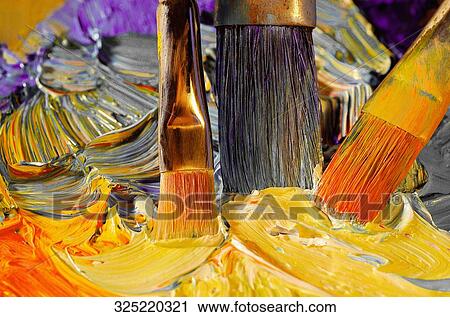 Stock Image - Close-up of paintbrushes mixing the paint. Fotosearch