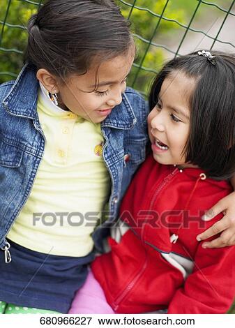 Close-up of two girls looking at each other View Large Photo Image Stock Photo - Close-up of two girls looking at each other. Fotosearch