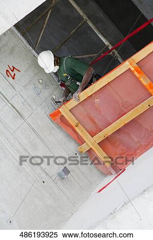 Construction worker making a wooden frame at a construction site View Large Photo Image Stock Photography - Construction worker making a wooden frame at a construction site. Fotosearch