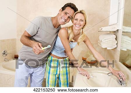 Couple brushing their teeth in the bathroom View Large Photo Image Stock Image - Couple brushing their teeth in the bathroom. Fotosearch