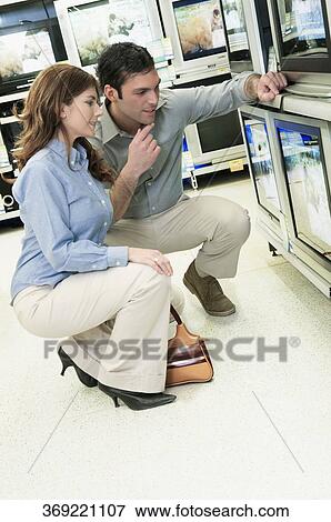 Couple buying a television in a supermarket View Large Photo Image Stock Photo - Couple buying a television in a supermarket. Fotosearch