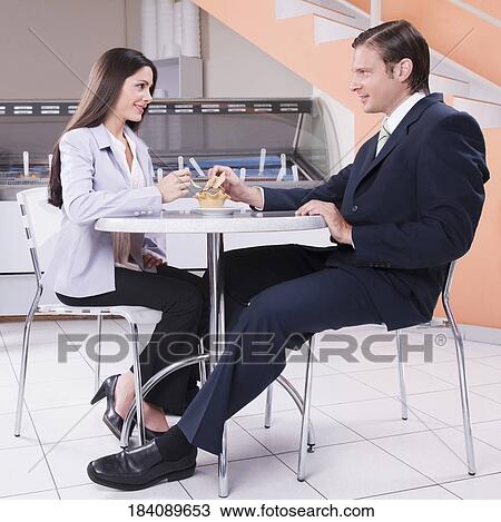Stock Image - Couple eating ice cream in an ice cream parlor. Fotosearch