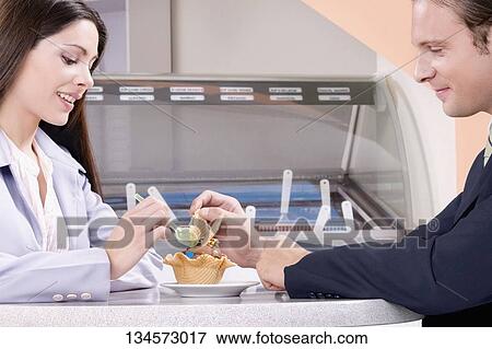 Couple eating ice cream in an ice cream parlor View Large Photo Image Stock Photo - Couple eating ice cream in an ice cream parlor. Fotosearch