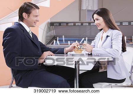 Couple eating ice cream in an ice cream parlor View Large Photo Image Stock Photo - Couple eating ice cream in an ice cream parlor. Fotosearch