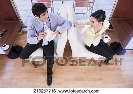 Couple eating sandwich in a restaurant View Large Photo Image Stock Photograph - Couple eating sandwich in a restaurant. Fotosearch