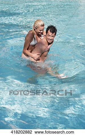 Stock Image - Couple having fun in a swimming pool, Biltmore Hotel, Coral Gables, Florida, USA. Fotosearch