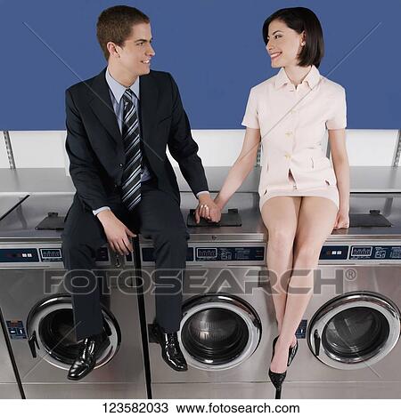 Couple holding hands and sitting on washing machines View Large Photo Image Stock Image - Couple holding hands and sitting on washing machines. Fotosearch