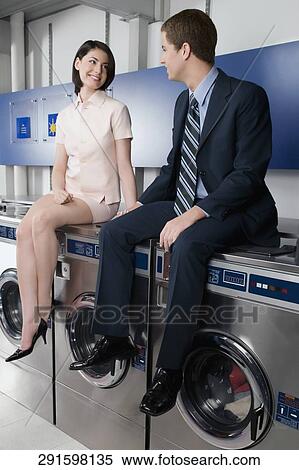 Couple holding hands and sitting on washing machines View Large Photo Image Stock Photography - Couple holding hands and sitting on washing machines. Fotosearch