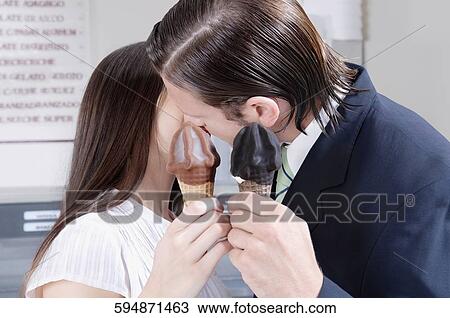 Couple holding ice cream and kissing each other View Large Photo Image Stock Image - Couple holding ice cream and kissing each other. Fotosearch