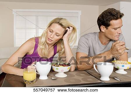Couple ignoring each other at breakfast View Large Photo Image Stock Photo - Couple ignoring each other at breakfast. Fotosearch