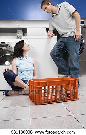 Couple in a laundromat View Large Photo Image Stock Photo - Couple in a laundromat. Fotosearch