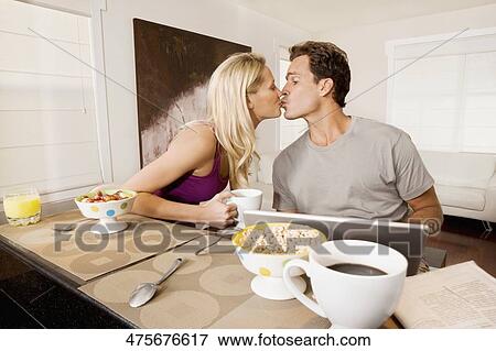 Couple kissing each other at a breakfast View Large Photo Image Stock Photo - Couple kissing each other at a breakfast. Fotosearch