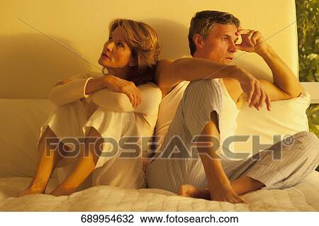 Couple looking serious on the bed View Large Photo Image Stock Image - Couple looking serious on the bed. Fotosearch