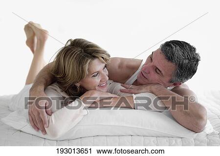 Couple lying on the bed and smiling View Large Photo Image Stock Image - Couple lying on the bed and smiling. Fotosearch