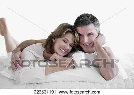 Couple lying on the bed and smiling View Large Photo Image Stock Image - Couple lying on the bed and smiling. Fotosearch