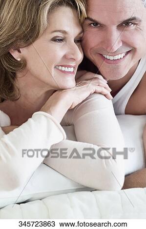 Couple lying on the bed and smiling View Large Photo Image Stock Image - Couple lying on the bed and smiling. Fotosearch