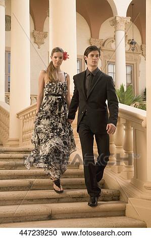 Stock Image - Couple moving down steps, Biltmore Hotel, Coral Gables, Florida, USA. Fotosearch