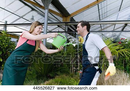 Stock Photo - Couple playing in a greenhouse. Fotosearch