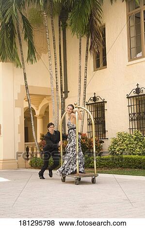 Couple playing with a trolley in front of a hotel, Biltmore Hotel, Coral Gables, Florida, USA View Large Photo Image Stock Photo - Couple playing with a trolley in front of a hotel, Biltmore Hotel, Coral Gables, Florida, USA. Fotosearch