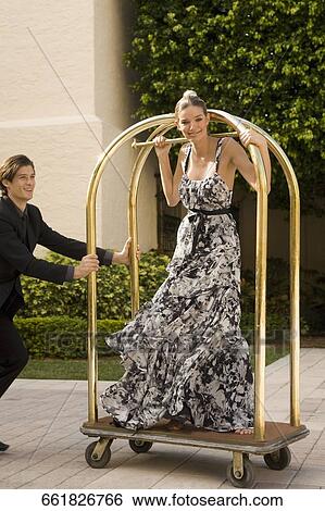 Couple playing with a trolley in front of a hotel, Biltmore Hotel, Coral Gables, Florida, USA View Large Photo Image Stock Photograph - Couple playing with a trolley in front of a hotel, Biltmore Hotel, Coral Gables, Florida, USA. Fotosearch