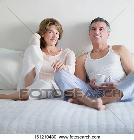 Couple reclining on the bed and smiling View Large Photo Image Stock Image - Couple reclining on the bed and smiling. Fotosearch