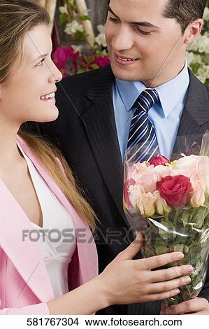 Picture - Couple romancing at a flower shop. Fotosearch