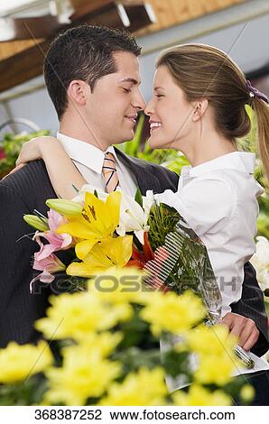 Stock Image - Couple romancing at a flower shop. Fotosearch
