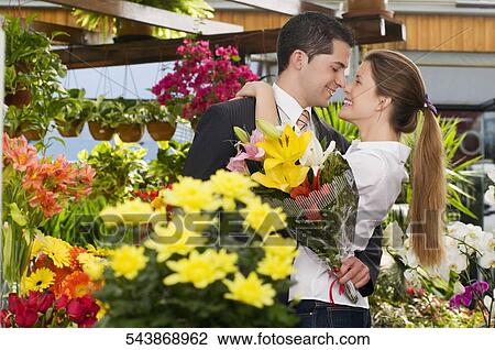 Couple romancing at a flower shop View Large Photo Image Stock Image - Couple romancing at a flower shop. Fotosearch