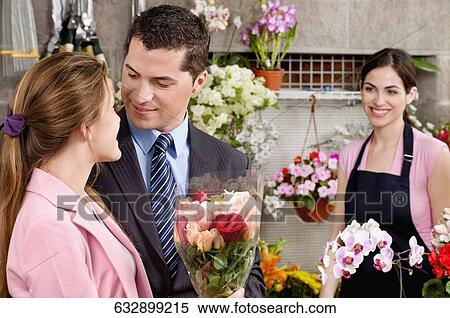 Stock Photography - Couple romancing at a flower shop. Fotosearch