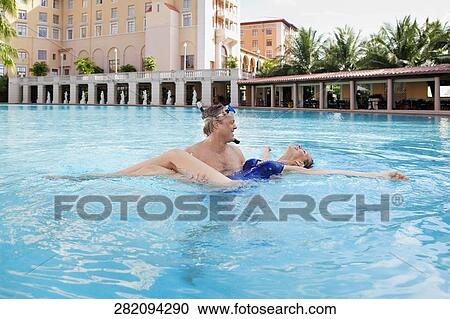 Couple romancing in a swimming pool, Biltmore Hotel, Coral Gables, Florida, USA View Large Photo Image Stock Image - Couple romancing in a swimming pool, Biltmore Hotel, Coral Gables, Florida, USA. Fotosearch