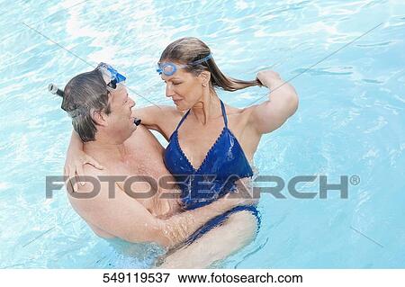 Stock Photo - Couple romancing in a swimming pool, Biltmore Hotel, Coral Gables, Florida, USA. Fotosearch