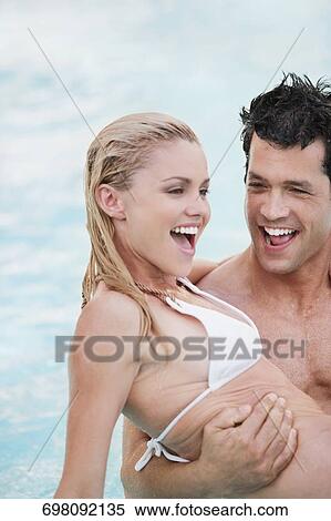 Stock Photography - Couple romancing in a swimming pool, Biltmore Hotel, Coral Gables, Florida, USA. Fotosearch