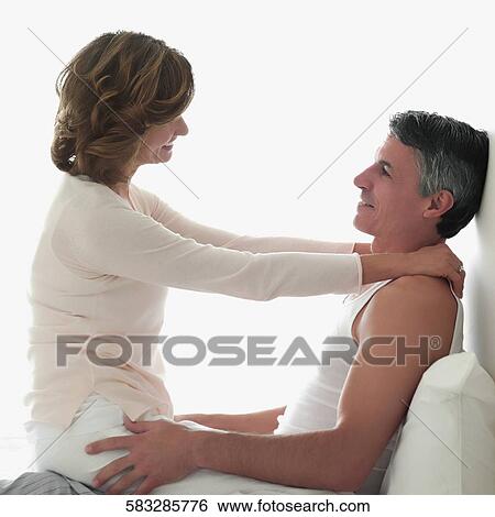 Stock Photograph - Couple romancing in the bedroom. Fotosearch